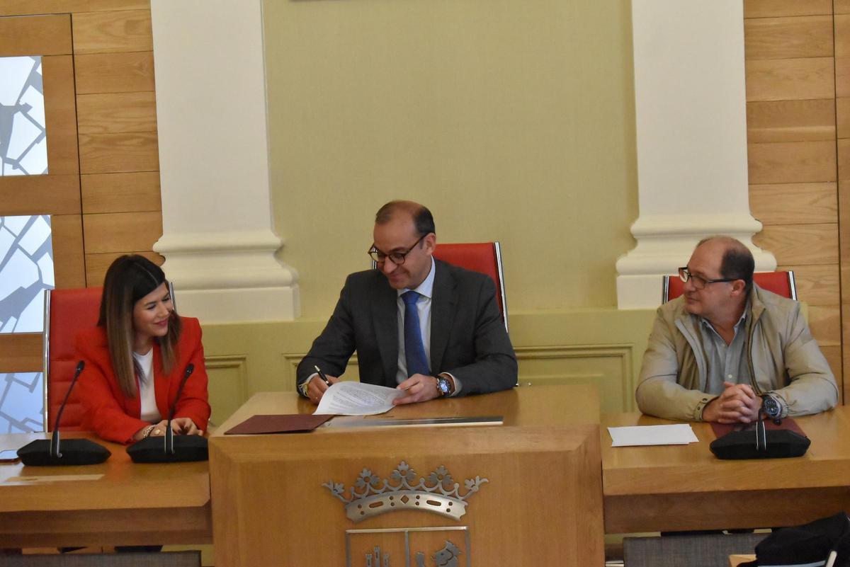 El alcalde, Rafa Mateos, firma el protocolo. A la izquierda, Encarna Solís.