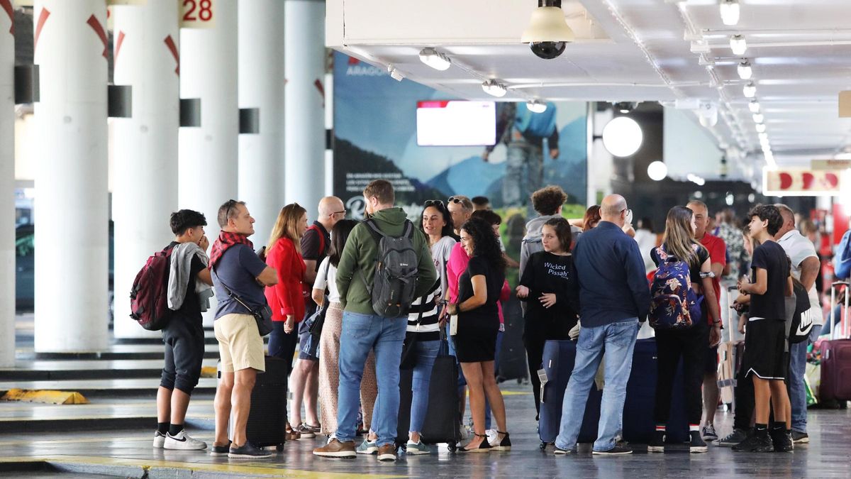 Varias personas esperan en la Estación Delicias de Zaragoza a la llegada de algún autobús