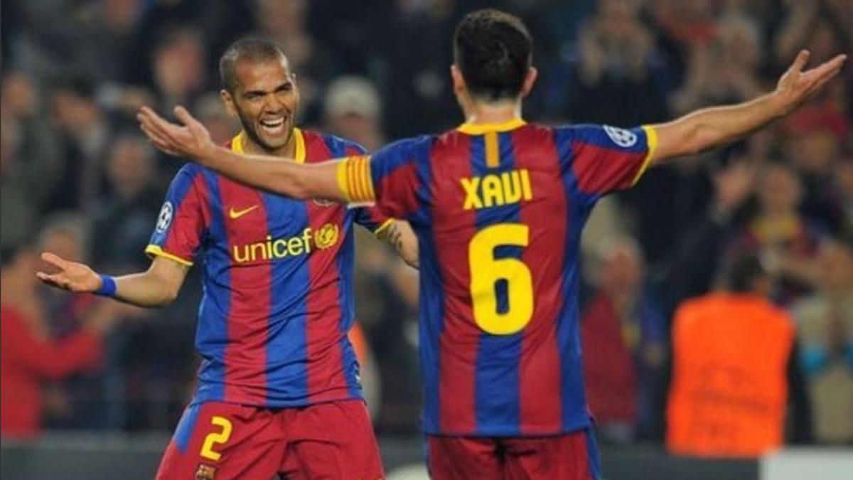 Alves y Xavi celebran un gol