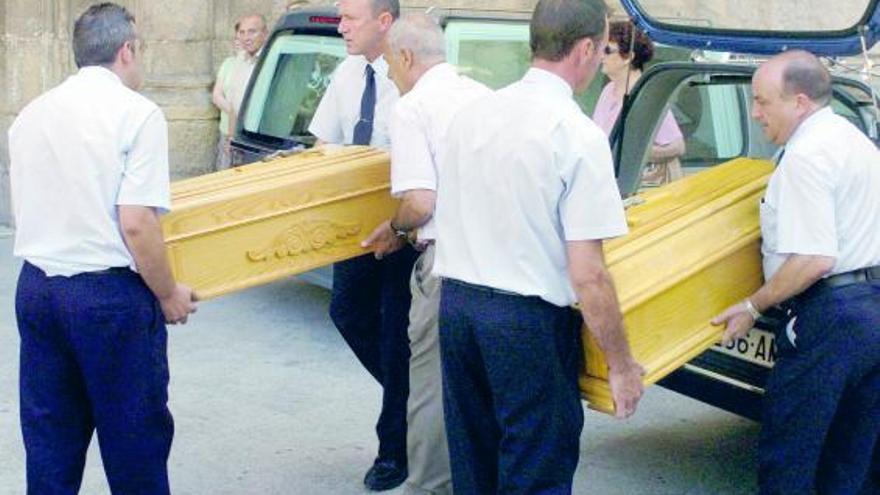 Los ataúdes de los dos pequeños, de 4 y 6 años, son introducidos en el coche fúnebre.