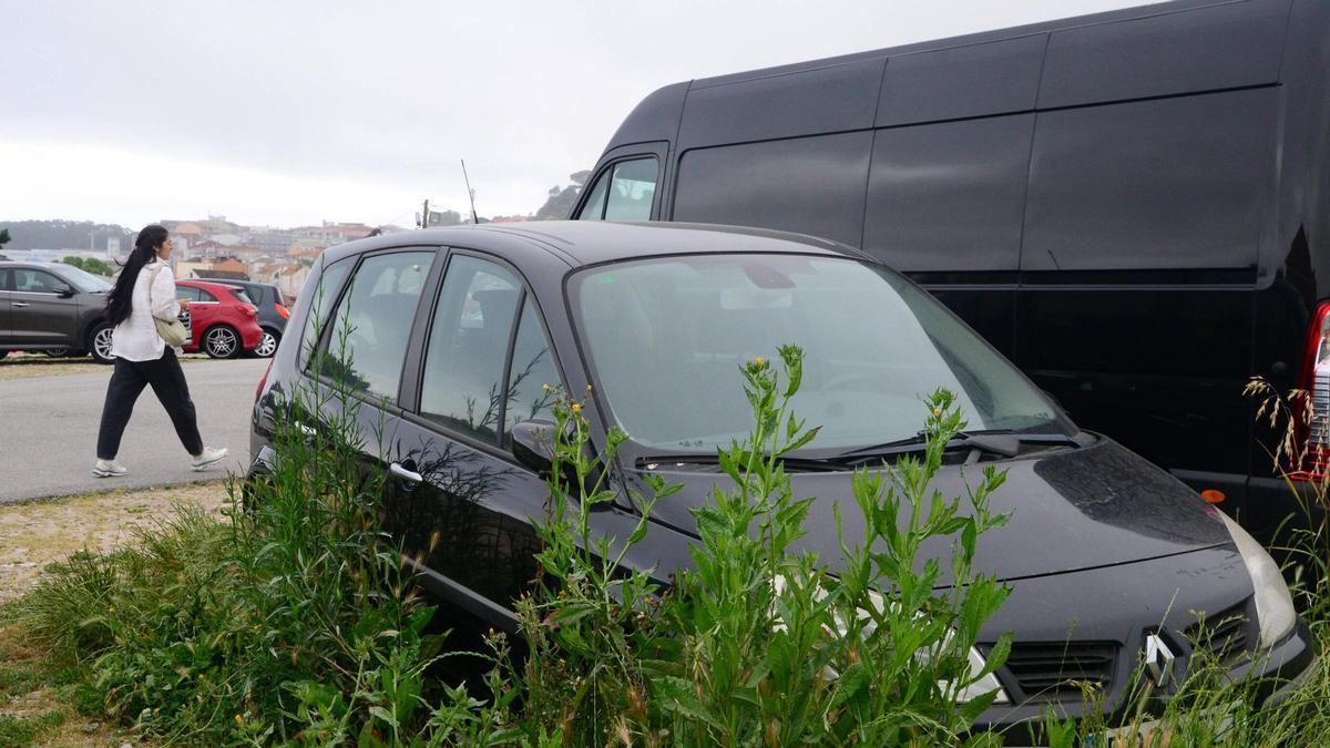 Coche abandonado en el parking público de tierra de Altamira