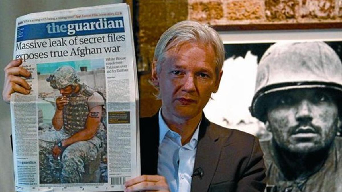 Julian Assange muestra una copia de 'The Guardian' durante una rueda de prensa en Londres en julio.
