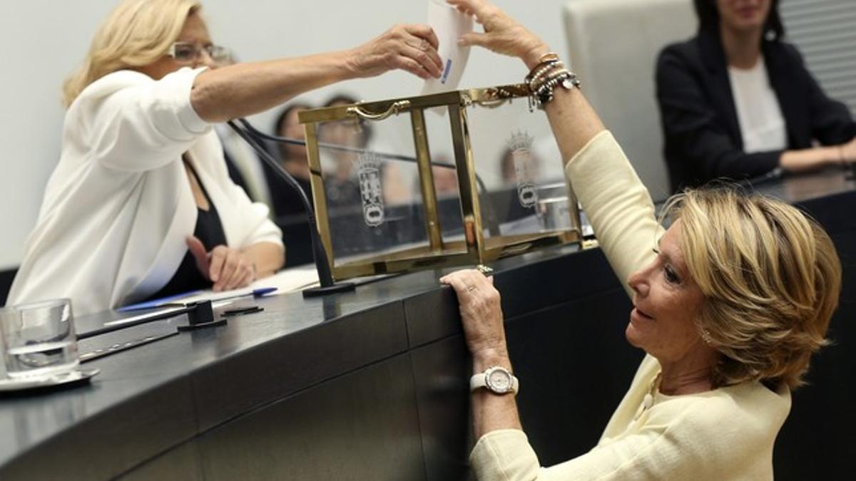 Manuela Carmena ayuda a votar a Esperanza Aguirre, durante la votación de investidura, el sábado en el Ayuntamiento de Madrid.