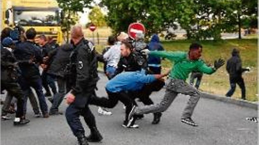 Diversos agents intenten controlar els immigrants a Calais.