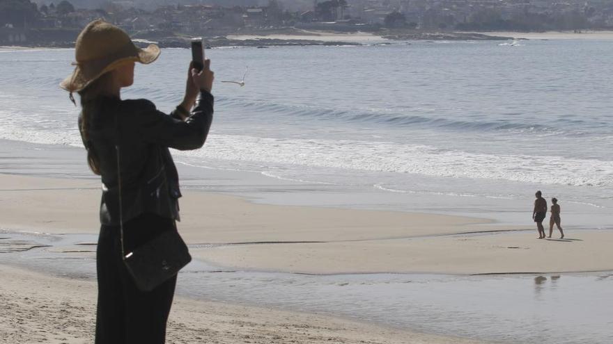 Una joven inmortalizando una jornada de sol en Samil. // A. Villar