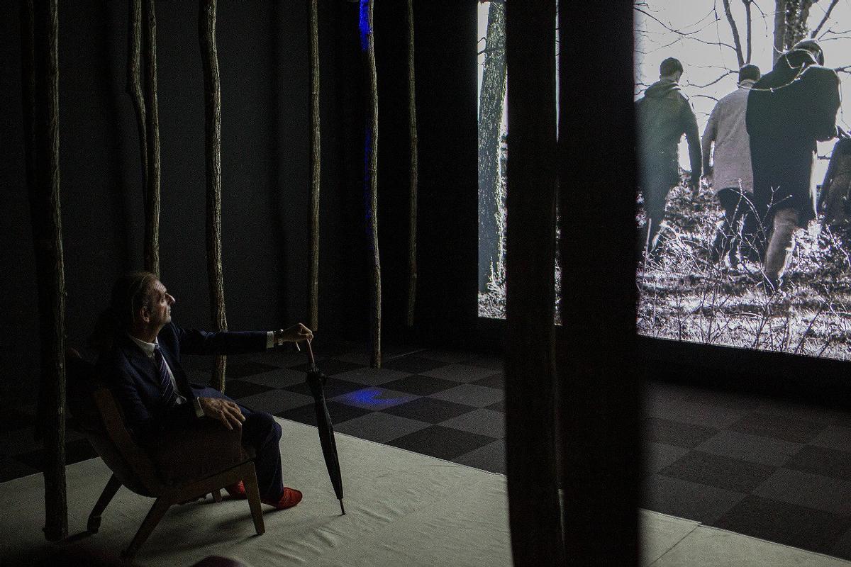 Una persona mirant la projecció de la instal·lació «Bosc tancat», instal·lada a la Rambla.