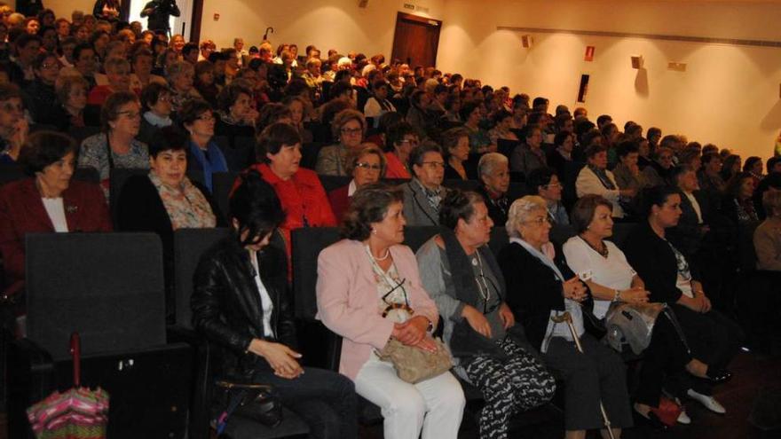 El público en el teatro Riera; a la derecha, la visita cultural de mujeres de Lena y Mieres.