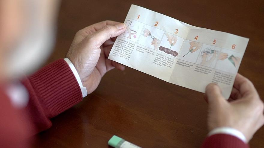Un hombre lee información sobre los test de cáncer de colon.