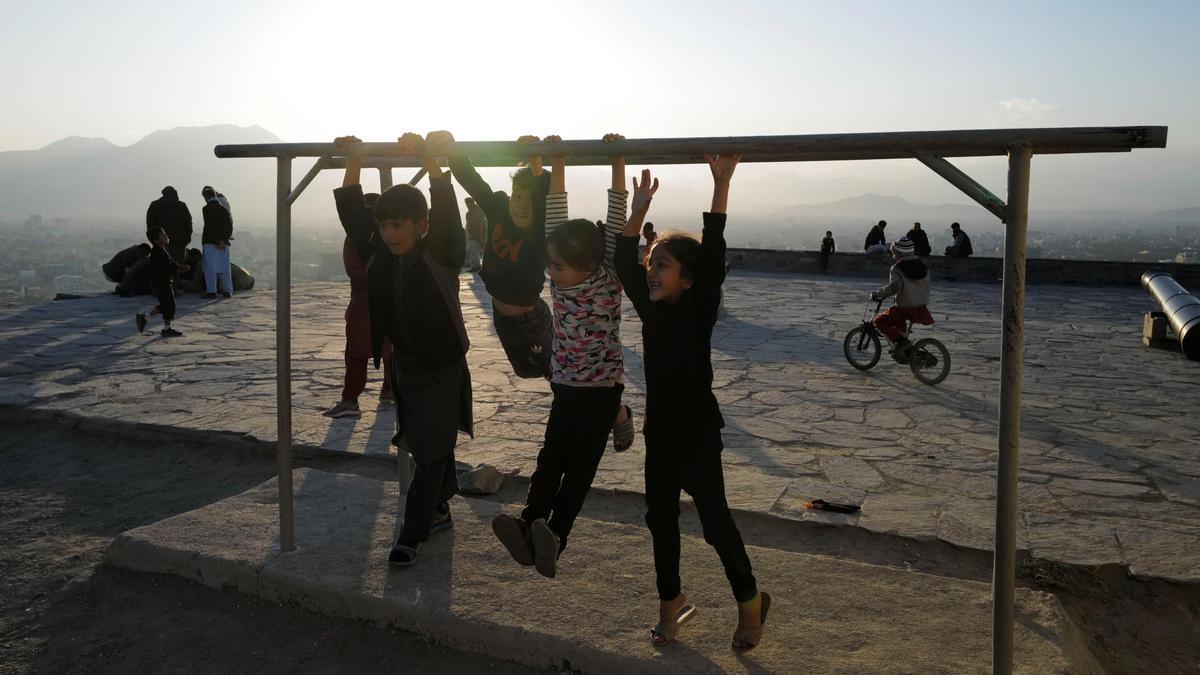 Children play on a hill top, in Kabul