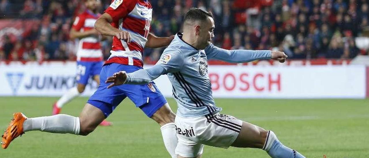 Iago Aspas conduce la pelota perseguido por un rival durante la reciente visita a Los Cármenes. // LOF