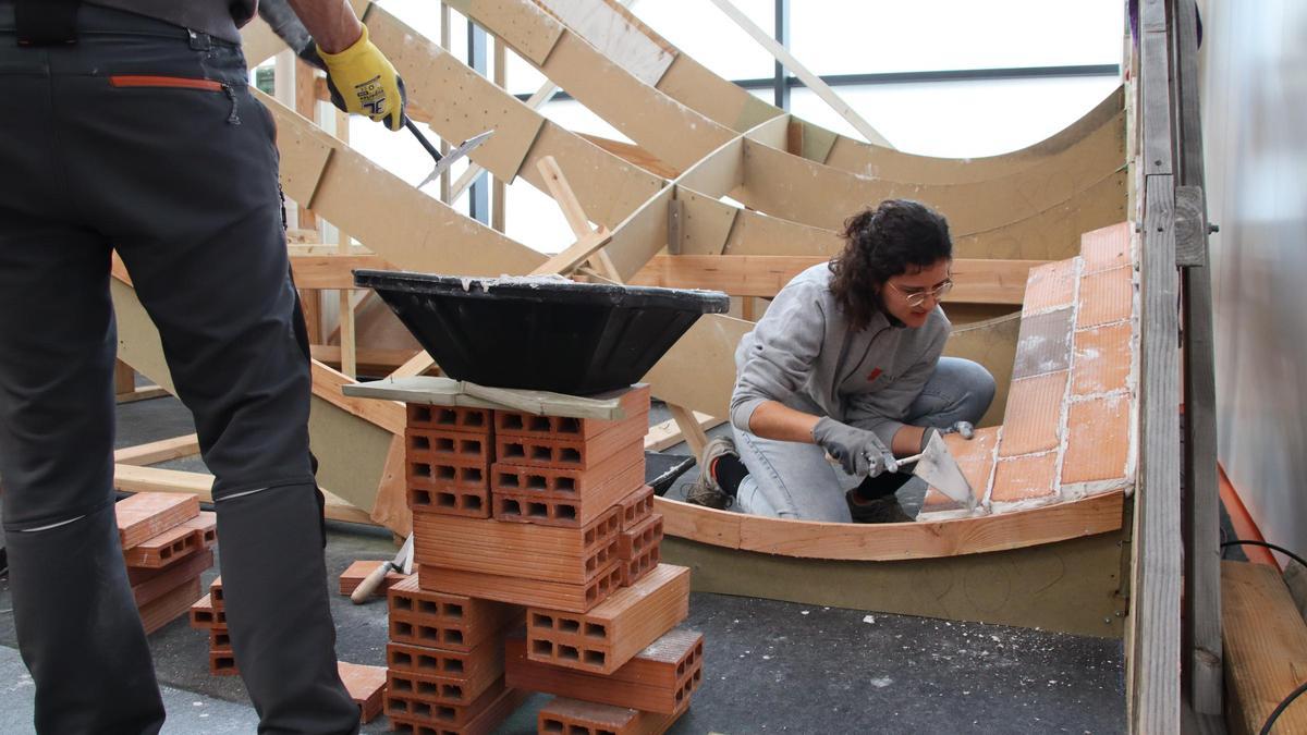 Una dona paleta fa una demostració de la construcció d'una teulada a la FECS de Vic