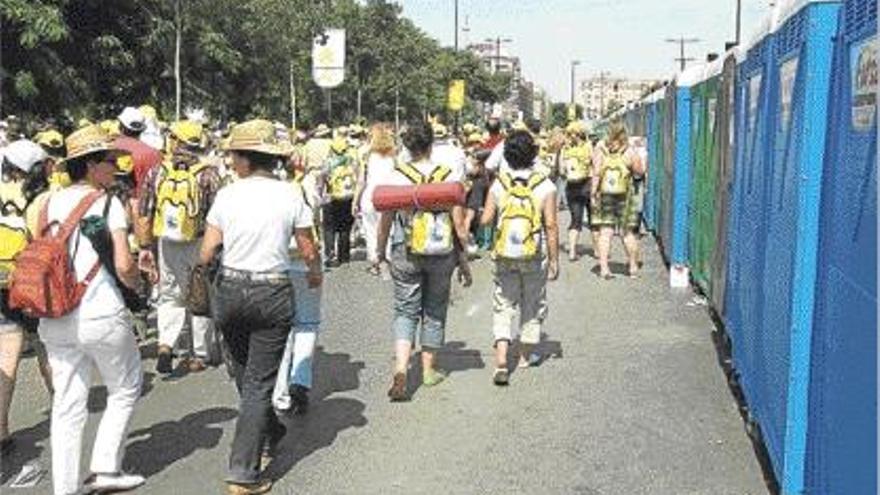 Peregrinos en la visita del Papa pasean ante una retahíla de urinarios móviles.