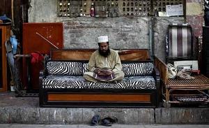 Noor Mohammed, un comerciant de 53 anys d’edat, llegeix l’Alcorà fora de la seva botiga de mobles a Mumbai (Índia).