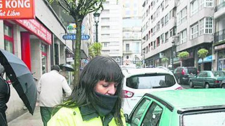 Una vigilante de la XER contrala una calle con zona azul. // J. de Arcos