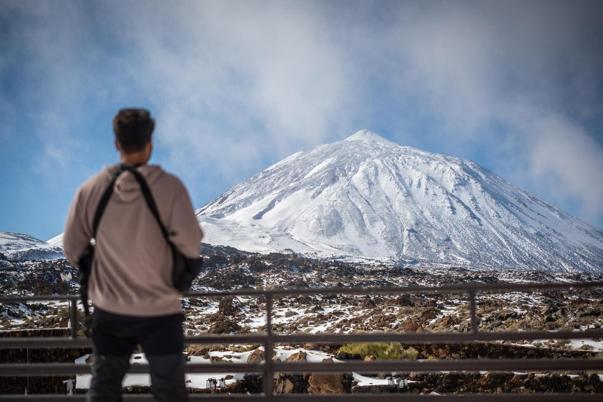 Un hombre mira hacia el Teide nevado.