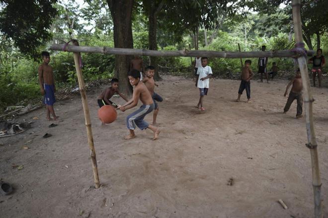 Los niños indígenas de Yukpa juegan al fútbol con una pelota irregular en la comunidad de Angeles del Tukuko en la ciudad fronteriza de El Tucuco, estado de Zulia, Venezuela, el 11 de junio de 2019.