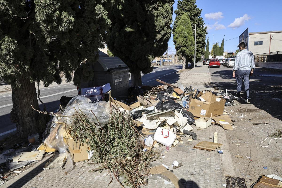 Un contenedor rodeado de enseres, en el barrio del Cementerio, este martes.