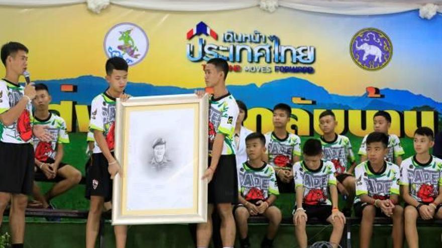 Els infants amb el dibuix del rostre del militar que va morir quan intentaven rescatar-los