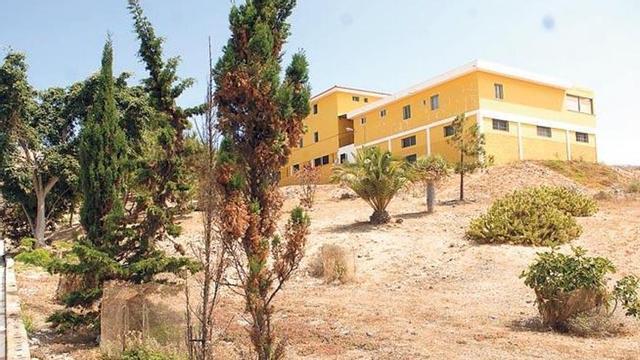 Vista del colegio público de Los Giles. Abajo, terrenos que rodean el centro escolar.