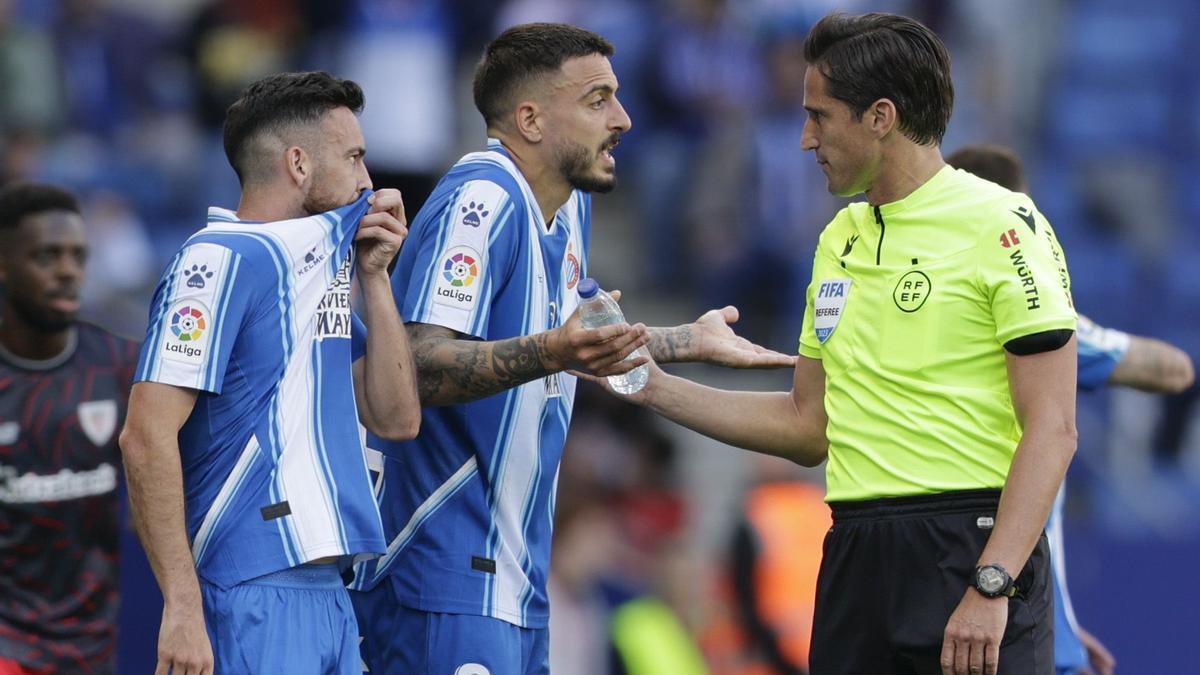 08/04/2023.- El árbitro Munuera Montero (d) habla con el delantero del Espanyol Joselu (c) tras anular el gol del delantero danés del Espanyol Braithwaite durante el partido la jornada 28 de la Liga Santander disputado esta tarde en el RCDE Stadium de Cornellà de Llobregat (Barcelona). EFE/ Quique García