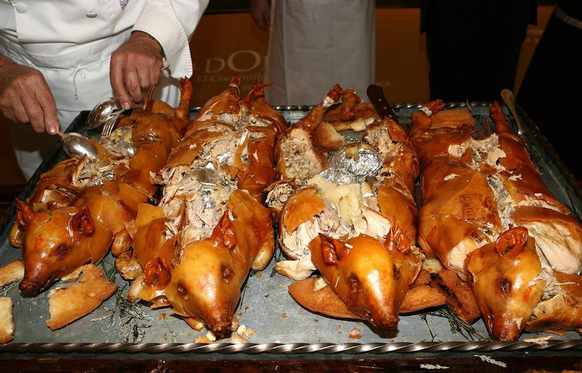 Un cocinero parte cuatro cochinillos en un restaurante de Segovia.