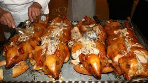 Un cocinero parte cuatro cochinillos en un restaurante de Segovia.
