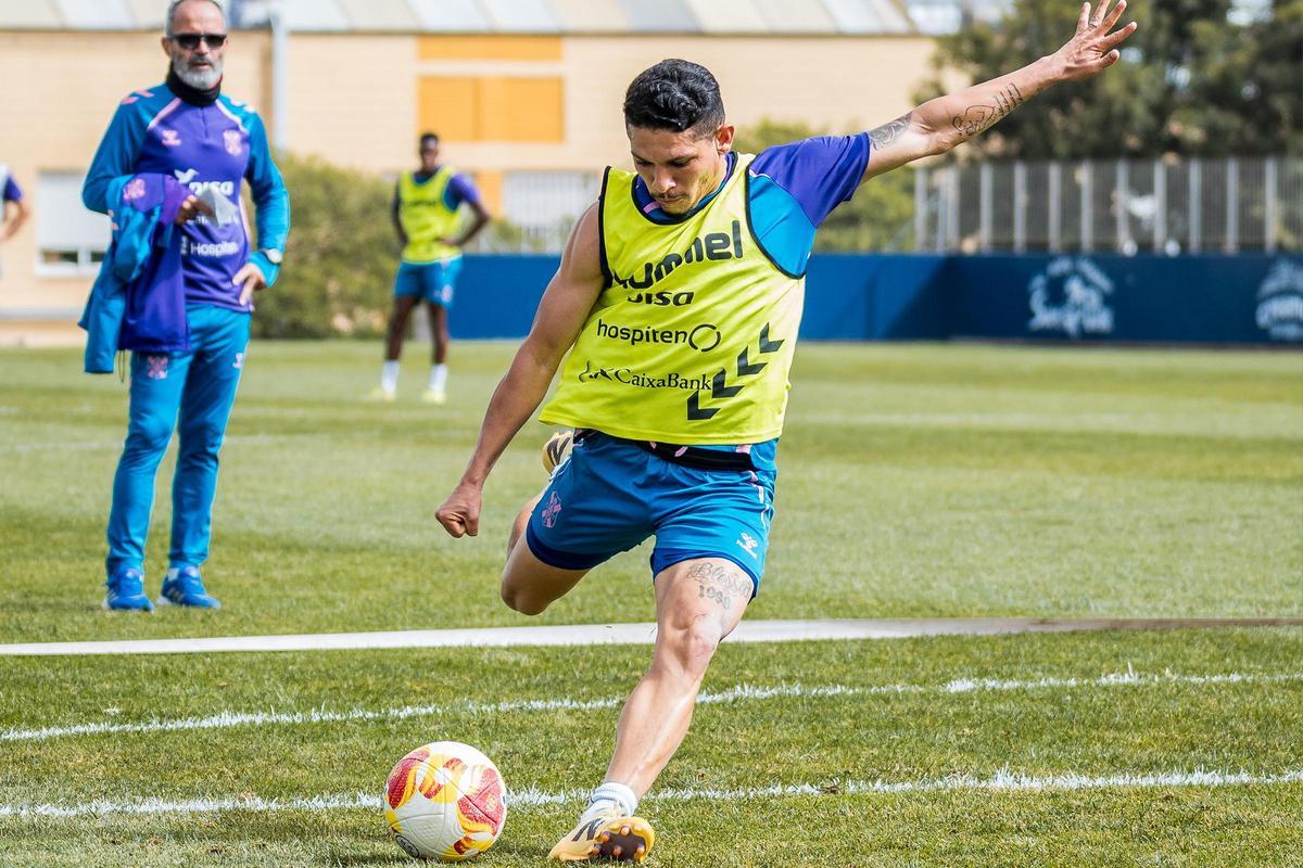 Fabricio golpea la pelota en un entrenamiento mientras Cervera sigue la acción.