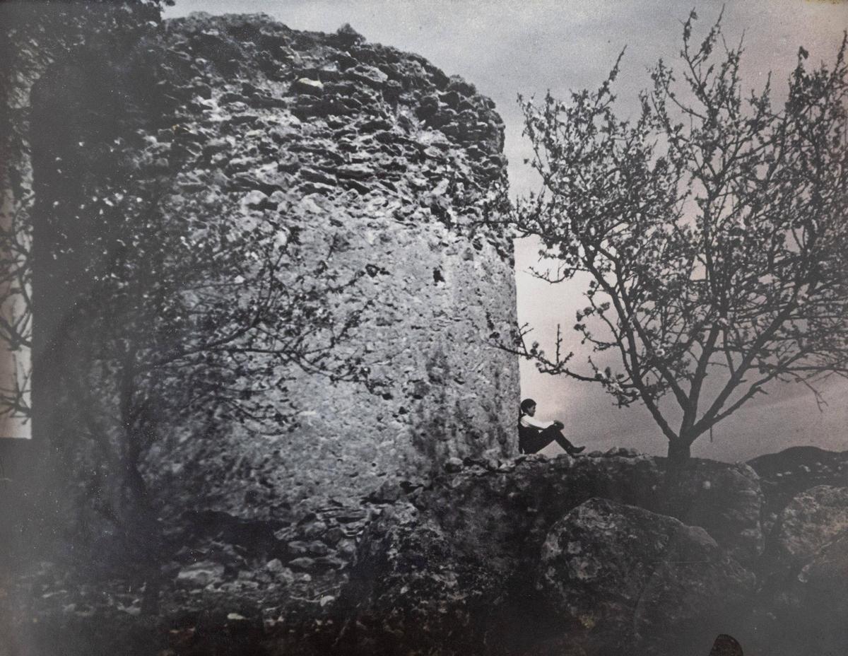 Imagen tomada por Harold Liebow en la que Alberto Torres Marí posa sentado junto una antigua torre de defensa de la isla.