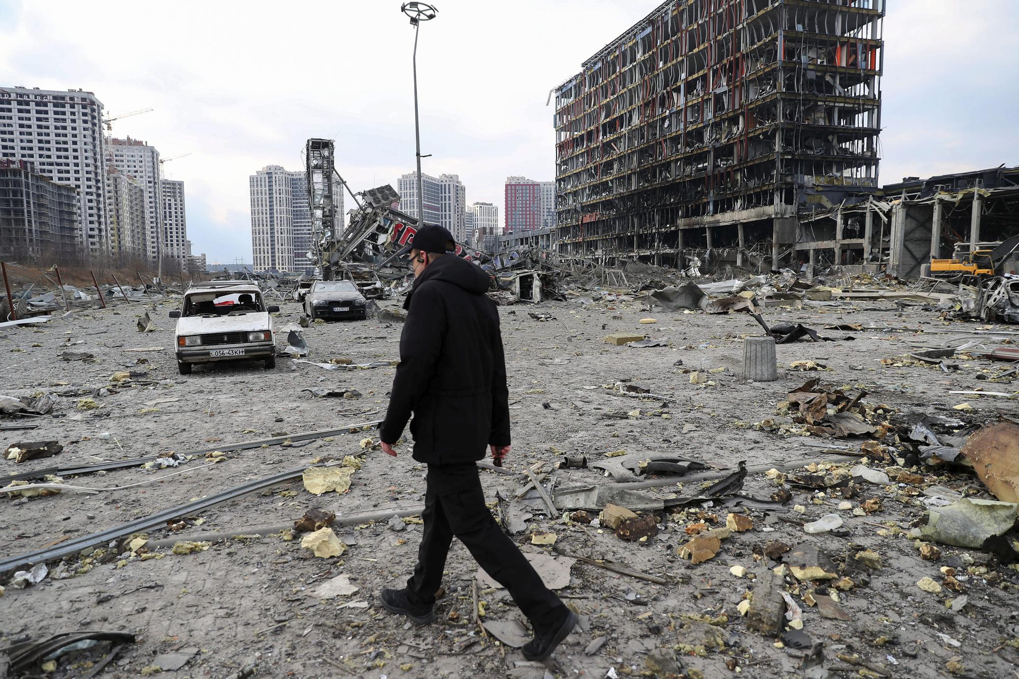 Un hombre pasea delante de un centro comercial bombardeado durante los ataques rusos en Kiev, 24 de marzo de 2022.