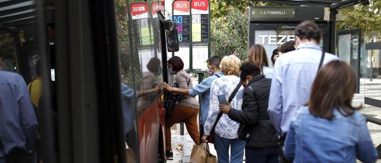 Los viajeros del bus hacen fila para acceder al vehículo en Zaragoza.