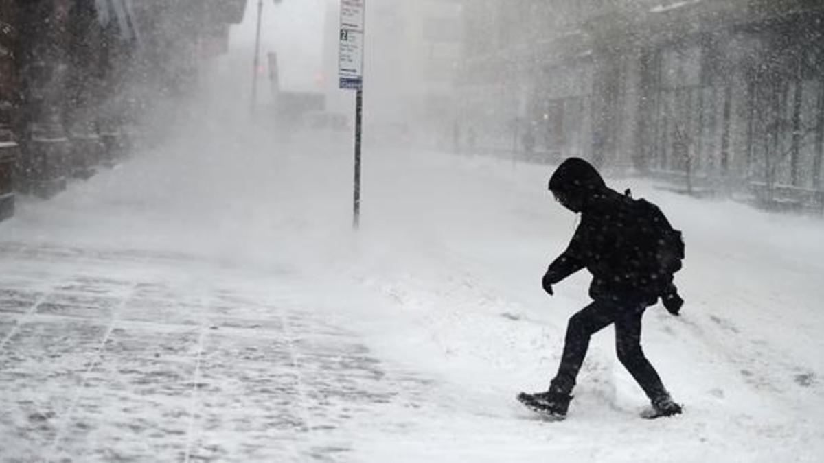 Un neoyorquino intenta avanzar a través de la tormenta de nieve en la ciudad.