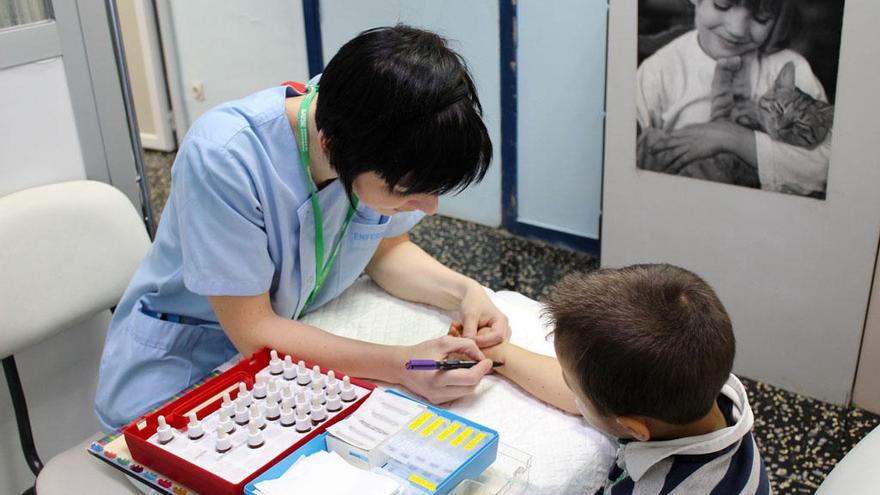 Una enfermera realiza la prueba de la alergia a un niño.