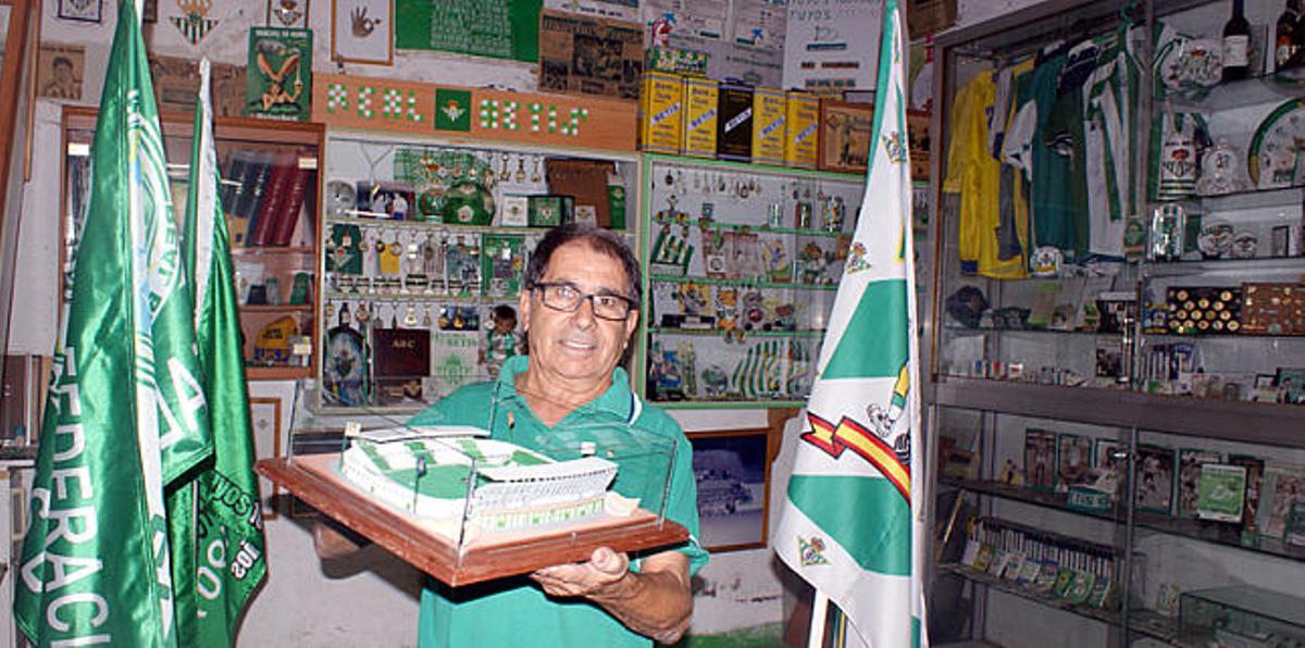 Juan Manuel Domínguez, en su museo del Betis, posa con una réplica del estadio Manuel Ruiz de Lopera. Detrás, su colección de llaveros. i LP / DLP