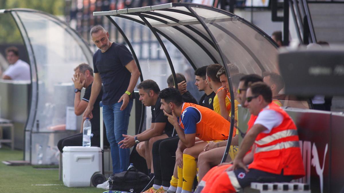 Ángel Rodríguez busca soluciones junto a su segundo en en banquillo durante el derbi en Paterna.