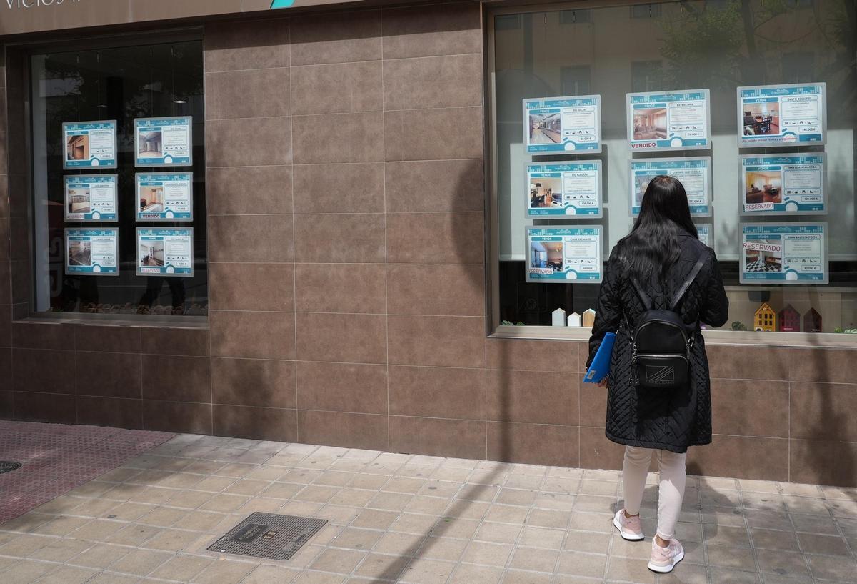 Una mujer mira las ofertas disponibles de alquiler en una inmobiliaria ubicada en Castellón (archivo).
