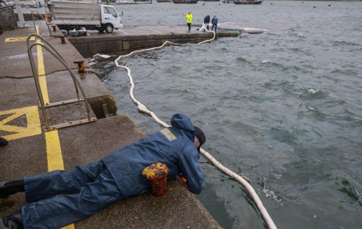 Efectivos de Gardacostas controlan una barrera anticontaminación. | IÑAKI ABELLA