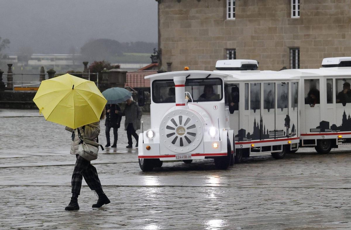 El tren turístico de Santiago, en el Obradoiro en una jornada lluviosa