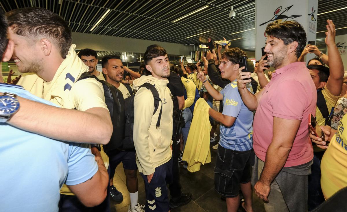 Aficionados reciben a la UD Las Palmas en el aeropuerto tras sellar el playoff