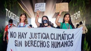 Tres jóvenes activistas se manifiestan durante la cumbre del clima de Sharm el-Sheikh.