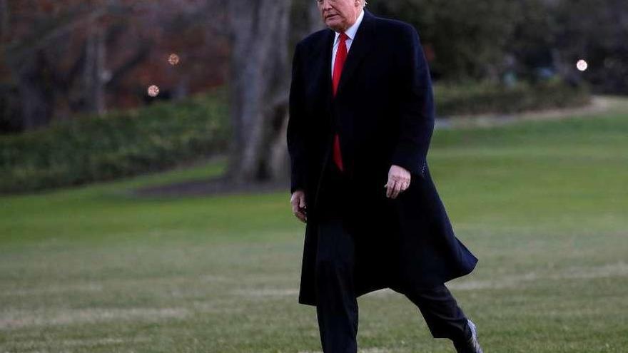 Trump camina por la Casa Blanca tras regresar de Misuri. En el recuadro, Michael Cohen. // Reuters