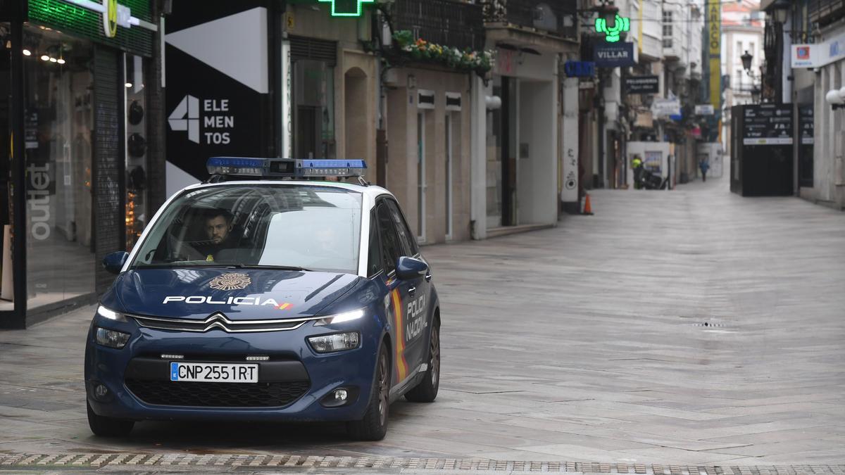 Un vehículo policial en la calle Real de A Coruña, vacía, durante el confinamiento.