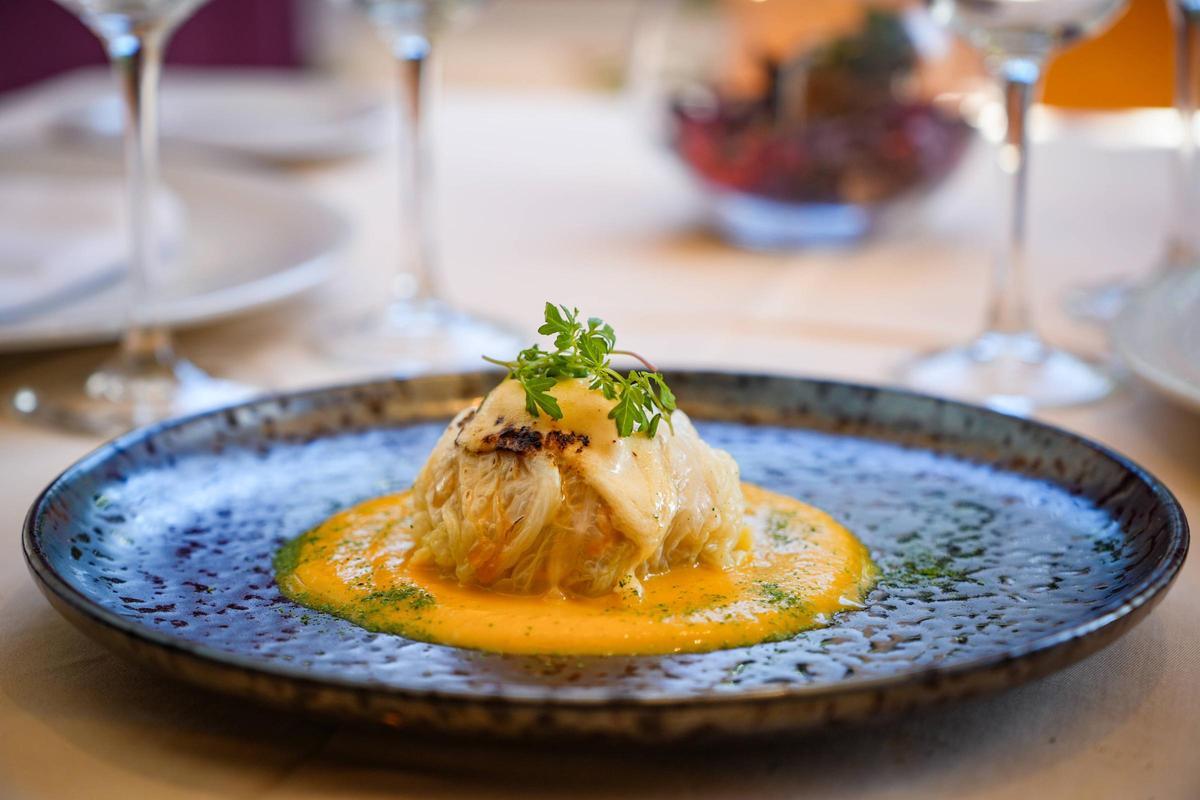 Esfera de col rellena de rape sobre puré de calabaza asada.