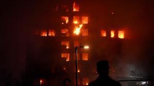 Un agente observa el edificio en llamas, en el barrio de Campanar, a 22 de febrero de 2024, en Valencia, Comunidad Valenciana (España)