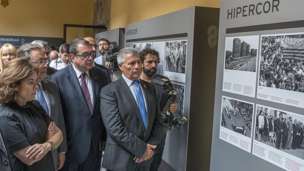 La vicepresidenta Soraya Sáenz de Santamaría, el ministro Juan Ignacio Zoido, el 'conseller' Jordi Jané y el presidente de la ACVOT, José Vargas, este lunes, en la exposición sobre el atentado de Hipercor.