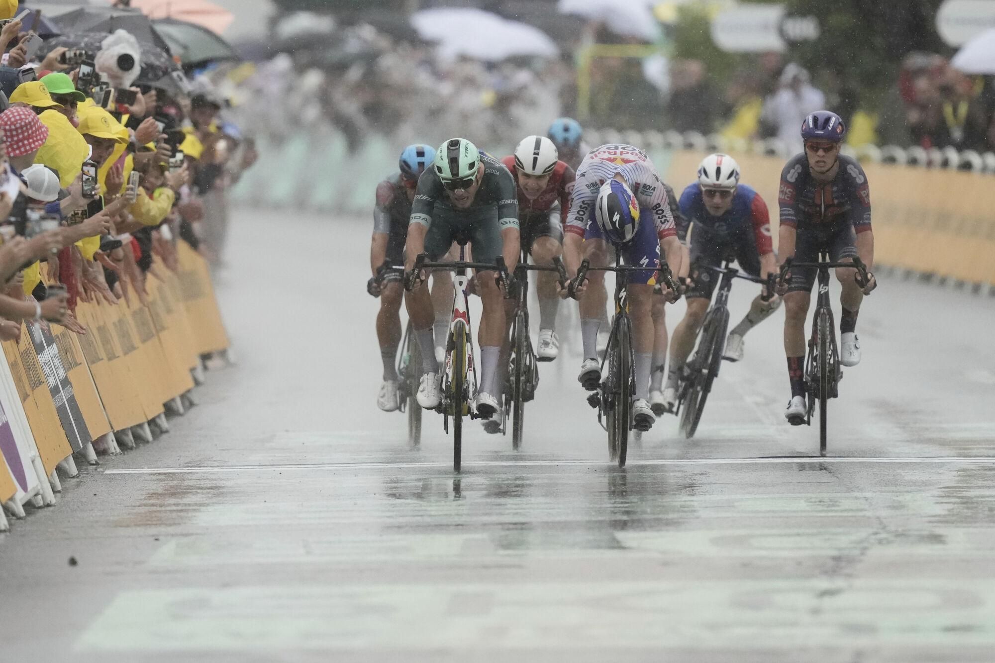 Italy's Jonathan Milan, left, crosses the finish line ahead of Belgium's Jordi Meeus to win the seventeenth stage of the Tour de France cycling race over 160.4 kilometers (99.7 miles) with start in Bollene and finish in Valence, France, Wednesday, July 23, 2025. (AP Photo/Thibault Camus)