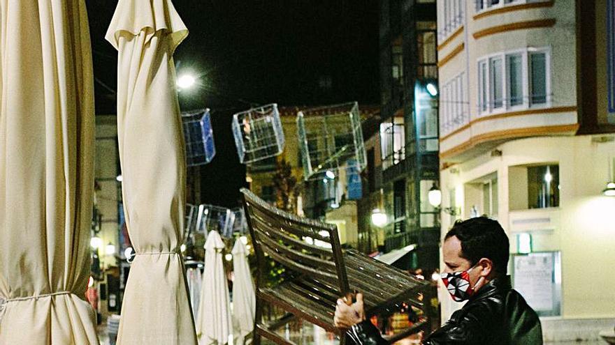 El dueño de un bar recoge la terraza durante el primer el cierre de la hostelería en Soria, el pasado mes de noviembre. | C. Ortega - Ical