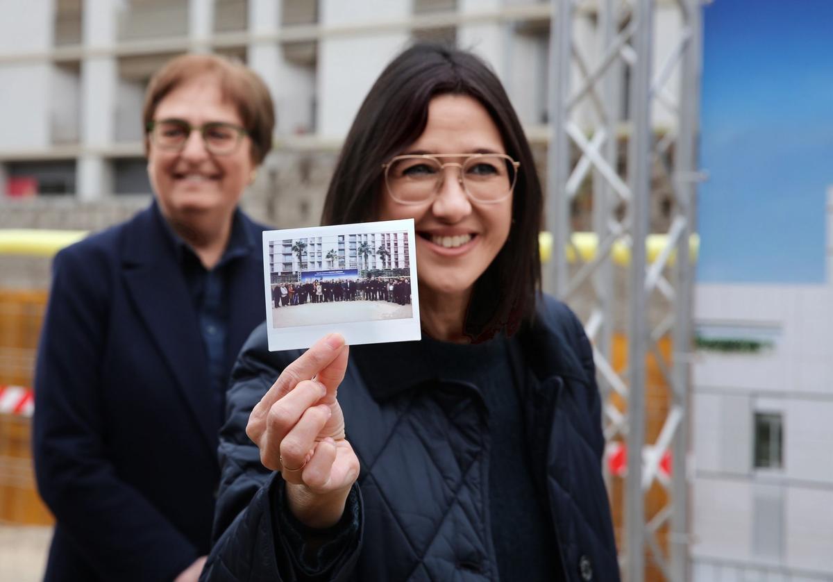 La alcaldesa Parlon muestra la fotografía instantanea que ha sido introducida en la cápsula del tiempo que se ha enterrado en las bases de la nueva comisaría