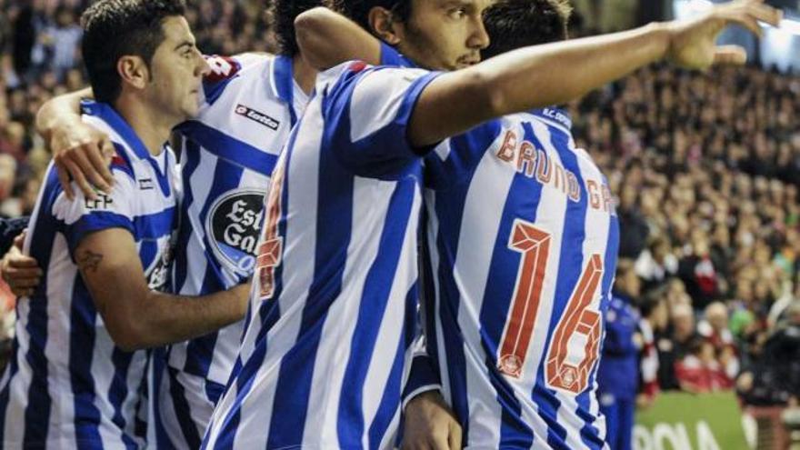 Abel Aguilar recibe las felicitaciones de sus compañeros tras marcar el gol del empate. / miguel toña / efe