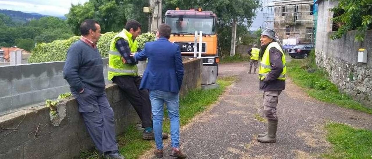 Vecinos afectados de Paramos ante las máquinas que realizaban la obra de servicios básicos.  // S.G.