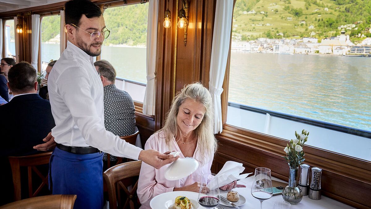 Servicio gastronómico a bordo del histórico barco de vapor Gallia durante el crucero premium Legends of Lake Lucerne.